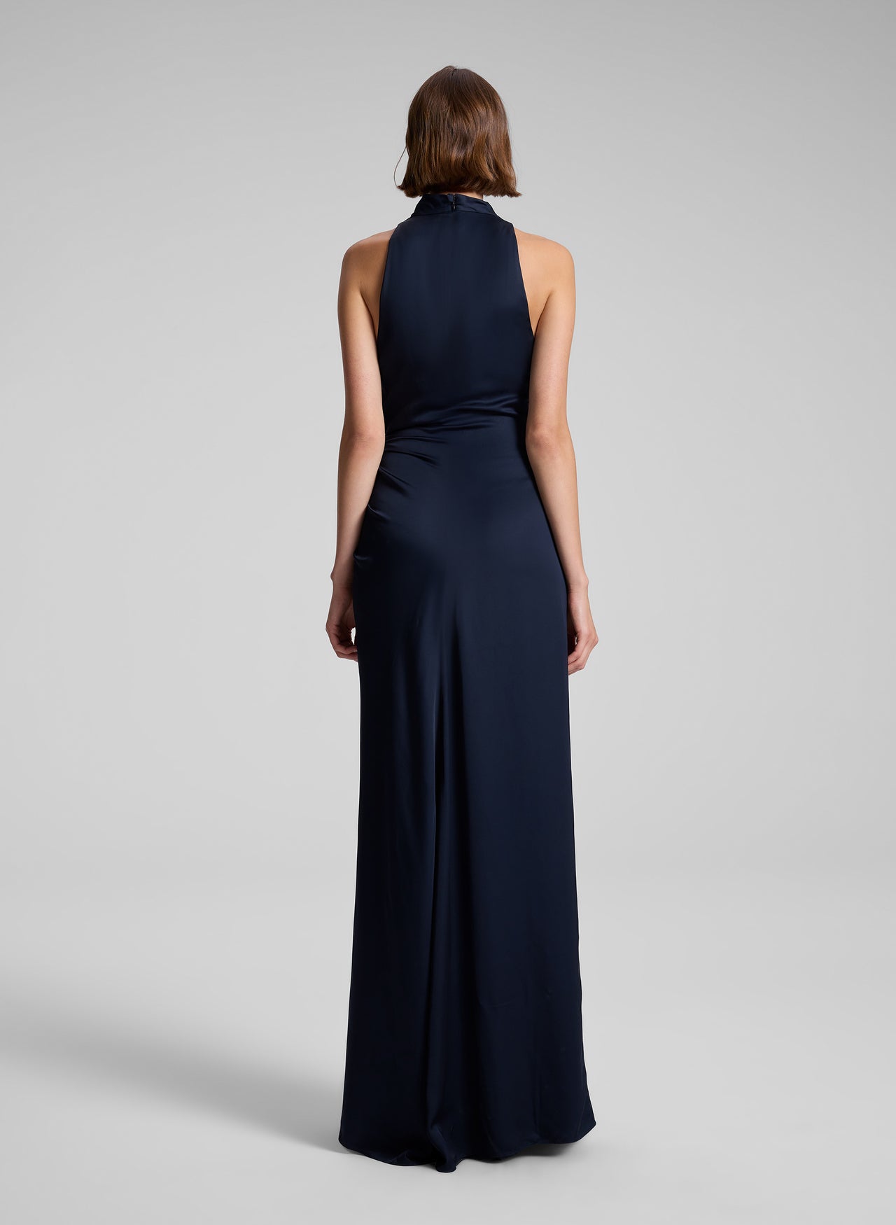 Navy blue halter neck gown on a plain background